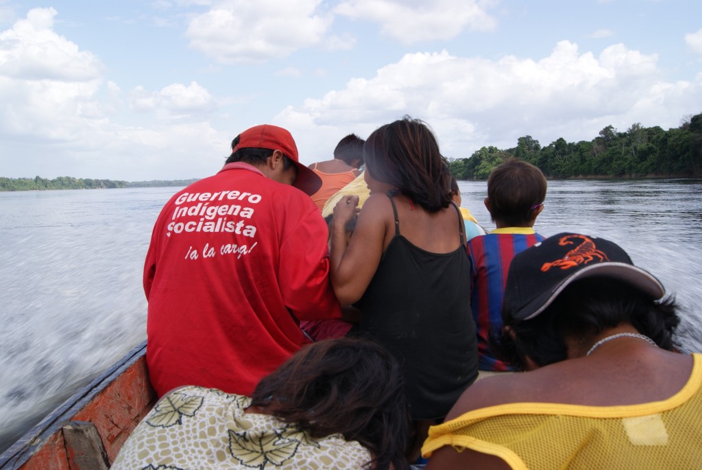 Figure 6: Indigenous community travelling to the city in their gasoline-powered canoe. One man wears a jackets proclaiming "Indigenous socialist warrior at your service!” Photo by the author.