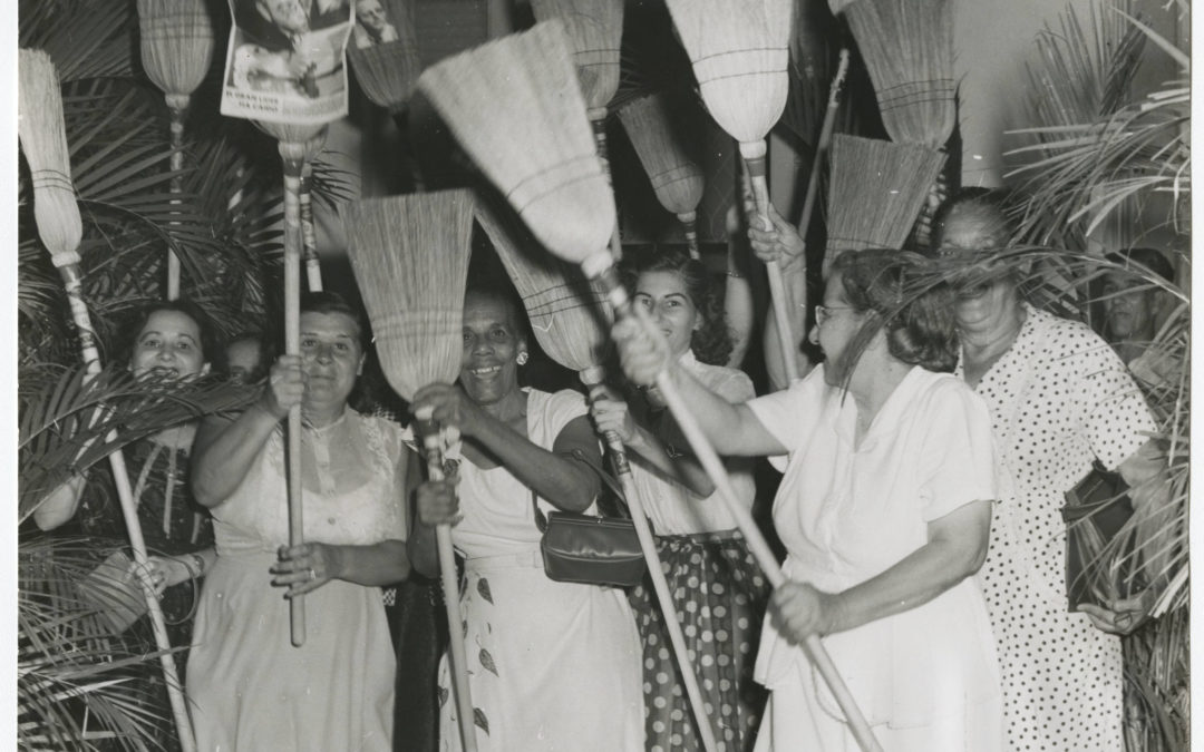 Group of women raising broomsticks in support of Eduardo Chibás